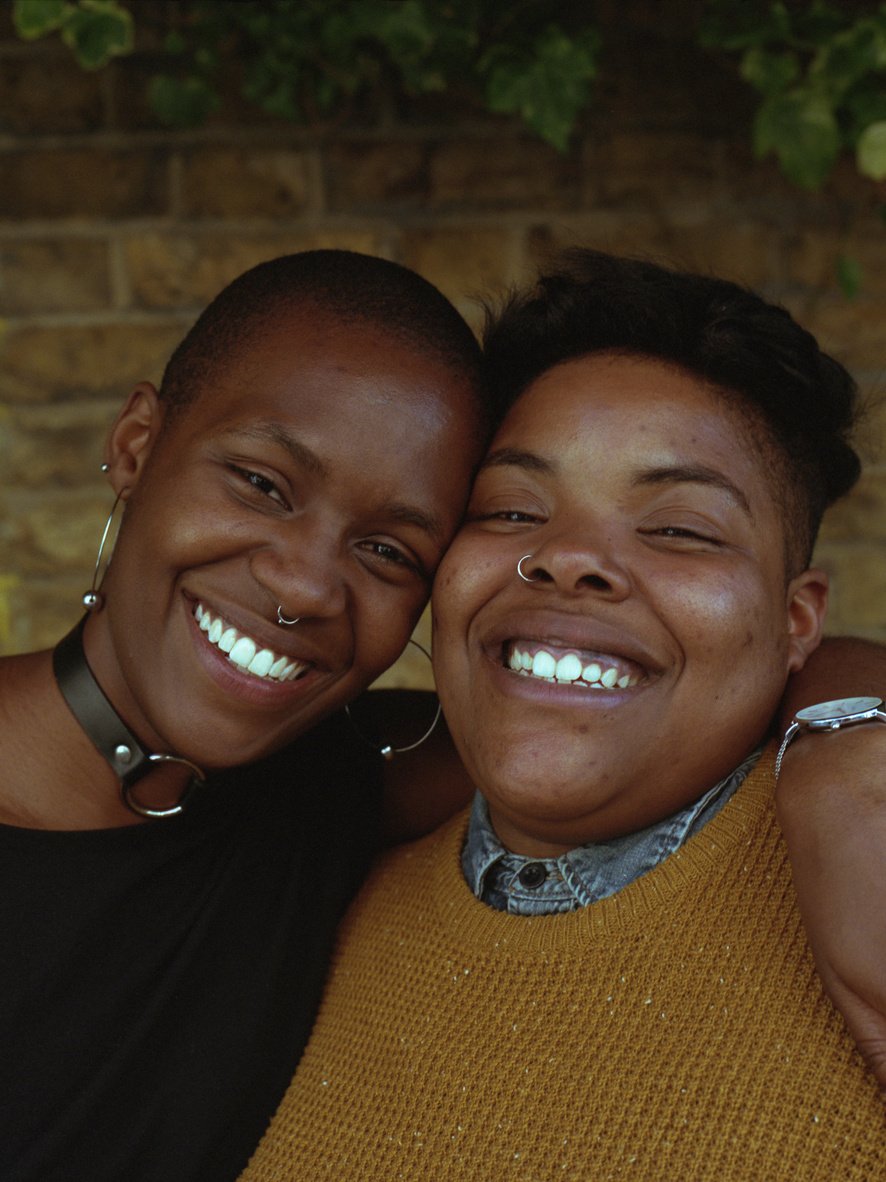 Two Smiling Queer Friends Embracing Each Other